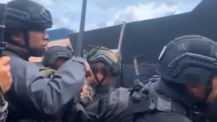 BERLINDUNG - Anggota brimob ini berlindung dibalik tembok di Pos Keamanan di Distrik Serambakun, Kabupaten Pegunungan Bintang, Papua Pegunungan. Upaya ini dilakukan untuk menghindari serangan yang dilakukan KKB Papua pada Senin 18 September 2023.