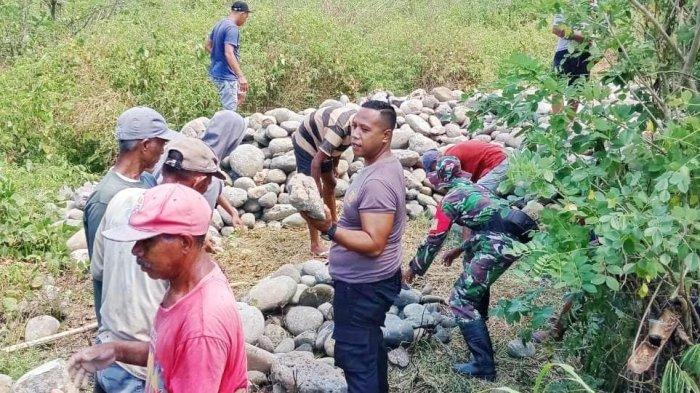 PERBAIKI - Polisi bersama masyarakat memperbaiki saluran sadap Bendungan Wae Sesap di Desa Poco Rutang, Kecamatan Lembor, yang jebol akibat hujan deras. Selasa (13/5)
