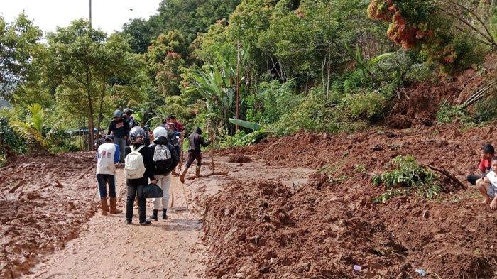 Selain banjir, hujan yang melanda Kabupaten Kerinci sejak Sabtu 30 Desember 2023 juga mengakibatkan tanah longsor. Tampak warga melintas di antara tanah longsor yang sempat menutup jalan.