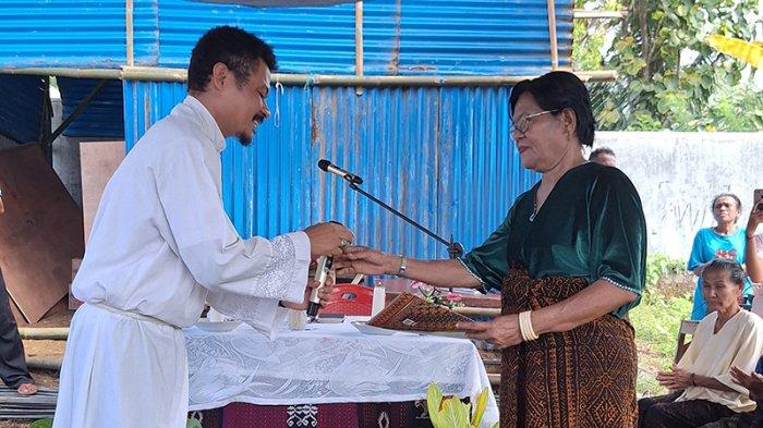 SERAHKAN SK PANITIA -  Pastor Paroki St. Maria Imaculata Jopu, Romo Frangki Aurelius Meze Siga (kiri) menyerahkan surat keputusan kepada Ketua Panitia, Sisilia Sona, Senin (26/5/2025).