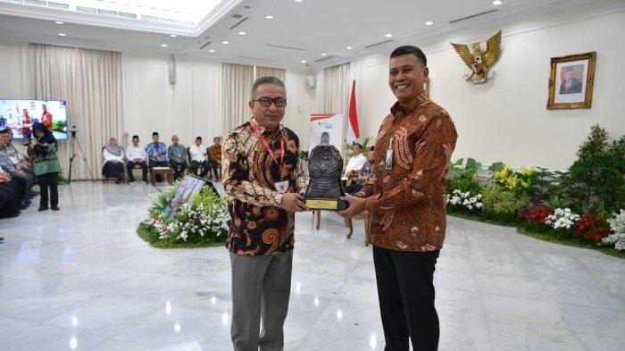 Direktur Utama BPR Tanaoba Lais Manekat, Robert Fanggidae menerima penghargaan dalam suatu kesempatan.