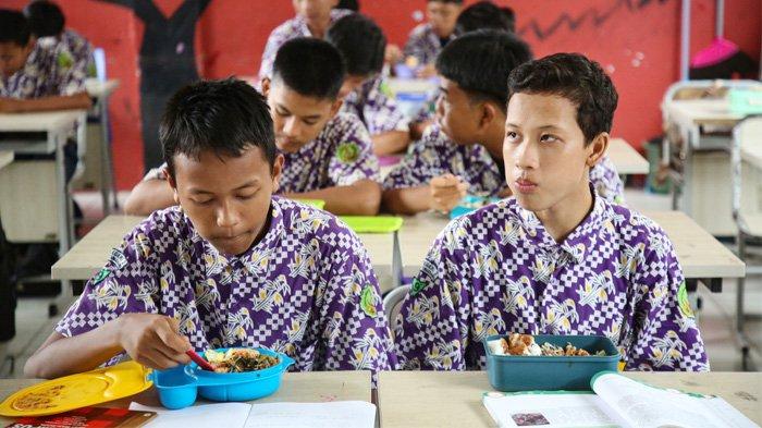 Siswa menikmati makan siang pada kegiatan simulasi program makan siang gratis di SMP Negeri 2 Curug, Kabupaten Tangerang, Banten, Kamis (29/2/2024). Pada kesempatan tersebut disediakan empat menu makan siang, yaitu siomay, gado-gado, ayam goreng, dan semur telur, senilai Rp 15.000 per porsi.