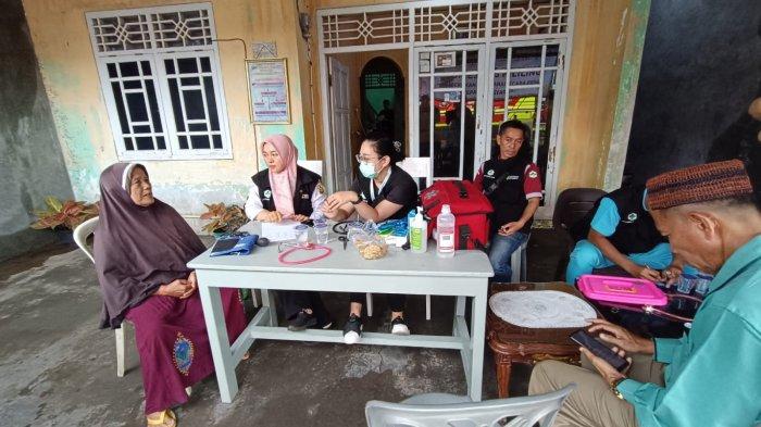 Korban banjir Rusni (kiri) saat melakukan pemeriksaan di posko kesehatan Pemkot Bandar Lampung, Minggu (23/2/2025).