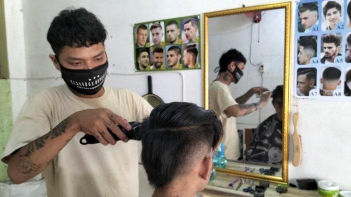 Tukang Cukur Rambut Keliling Pakai APD Jas Hujan Kini Punya Usaha