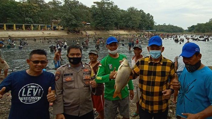 Wakil Bupati Pringsewu Fauzi bersama Bhabinkamtibmas dan Pokdarwis Telaga Gupit menunjukkan ikan hasil tangkapan berbobot sekitar 5 kg, Minggu (1/11/2020).