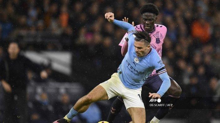 Gelandang Inggris Manchester City Jack Grealish (kiri) berebut bola dengan Amadou Onana (kanan)