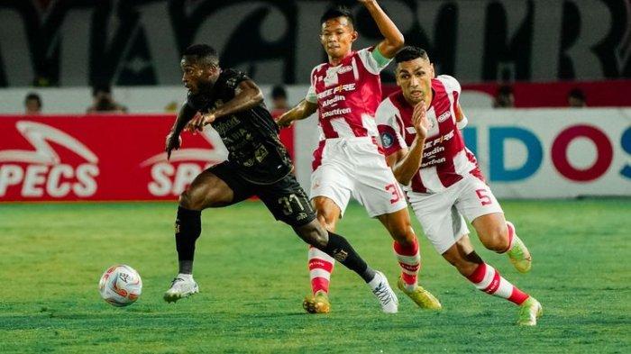 Dua pemain belakang Persis Solo, Jaimerson (5) dan Eky Taufik (30), berebut bola dengan pemain sayap Bali United, Privat Mbarga. Laga Persis Solo vs Bali United pada pekan kesembilan Liga 1 2023-2024 tersebut digelar di Stadion Manahan, Solo, Sabtu (19/8/2023) malam. Persis menang telak 3-1.
