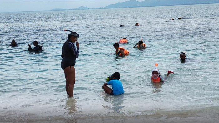 Para wisatawan bersama keluarga tengah snorkeling di Gili Nanggu, salah satu objek wisata Lombok favorit wisatawan.