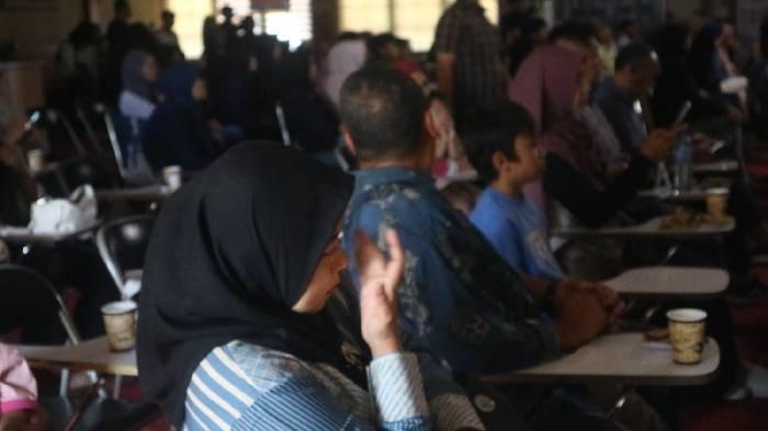 HUT ANAK - Seorang ibu nampak terharus saat melihat pementasan musikalisasi puisi oleh anggota Dewan Anak Mataram (DAM) ke-17 di Aula kantor Wali Kota Mataram, Selasa (13/5/2025).