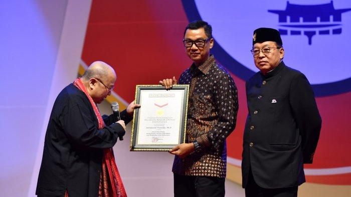 Pendiri Museum Rekor Indonesia (MURI) Jaya Suprana (kiri) menyerahkan rekor MURI kepada penulis buku biografi 
