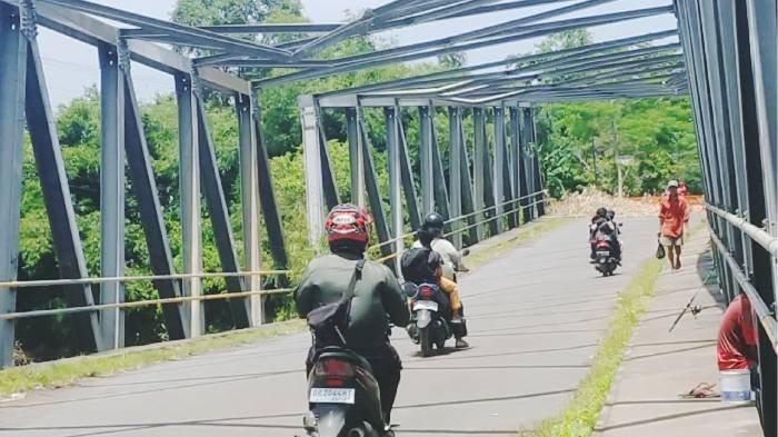 JEMBATAN MIRING  - Warga dan sejumlah pengendara nekat melintasi Jembatan Bakong, Kecamatan Lembar, Lombok Barat yang rusak parah, Minggu (16/2/2025). Meski sudah dipasangkan pembatas dan larangan melintas, warga tetap menggunakan jembatan itu karena aksesnya lebih cepat.
