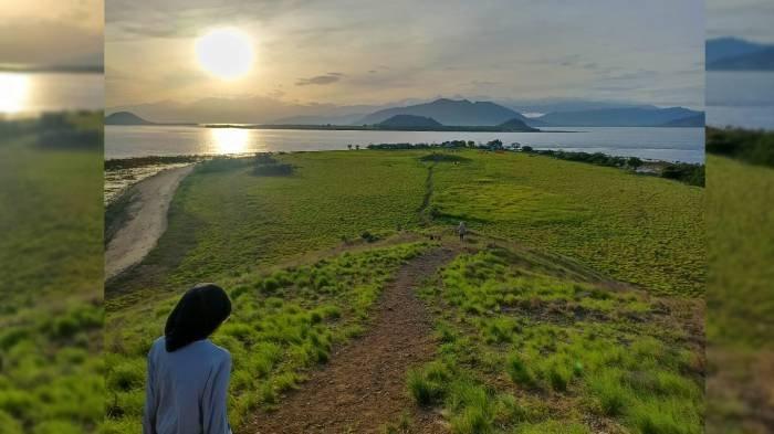 Seorang wisatawan menikmati suasana sunrise dengan hamparan savana di bukit Pulau Kenawa, Sumbawa, NTB, Minggu (11/2/2024). (TRIBUNLOMBOK.COM/LAILATUNNI'AM)