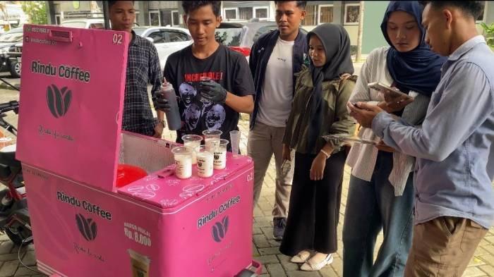KOPI KELILING - Salah seorang mahasiswa Universitas Muhammadiyah Mataram menjual Rindu Coffee di lingkungan kampus, Jumat (18/4/2025). Kopi keliling ini dirintis oleh dosen bernama Bedy Fara Aga Matrani.