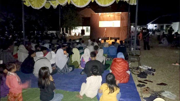 Para penonton wayang botol lapangan Desa Labulia, Lombok Tengah, Senin (29/7/2024) malam.