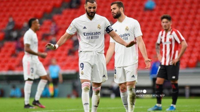 Penyerang Prancis Real Madrid Karim Benzema dan gerakan bek Spanyol Real Madrid Nacho Fernandez (kanan) selama pertandingan sepak bola Liga Spanyol antara Athletic Club Bilbao dan Real Madrid CF di stadion San Mames di Bilbao pada 16 Mei 2021. Real Madrid akan berjuang mati-matian untuk menjadi juara di kompetisi Liga Spanyol musim 2020/2021.