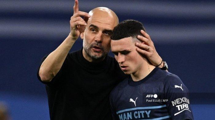 Manajer Manchester City asal Spanyol Pep Guardiola (kiri) menggantung gelandang Manchester City asal Inggris Phil Foden setelah pertandingan sepak bola leg kedua semifinal Liga Champions antara Real Madrid CF dan Manchester City di stadion Santiago Bernabeu di Madrid pada 4 Mei 2022.