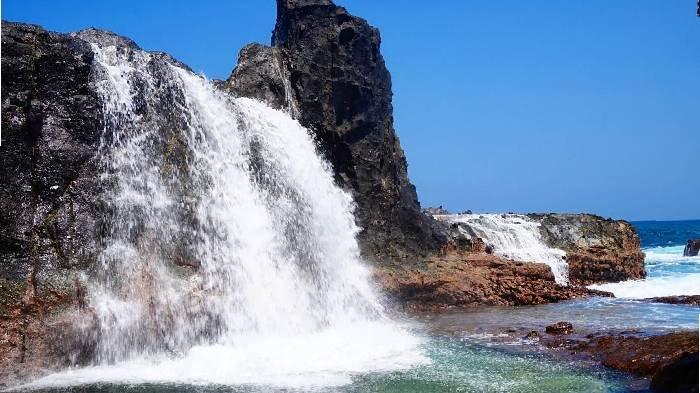 Pesona air terjun di Pantai Nambung Sekotong Lombok Barat. Biasanya air terjun itu ada di pegunungan atau hutan. Nah, di Pantai Nambung ini kamu bisa lihat air laut yang terhempas ke bebatuan, lalu jatuh seperti air terjun.