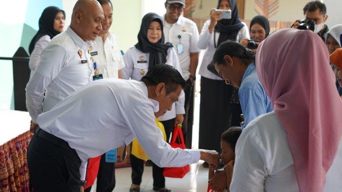 Kepala Kantor Wilayah Kemenkumham NTB, Romi Yudianto menyalami seorang anak saat bakti sosial di Kelurahan Monjok, Kota Mataram pada Rabu 2 Agustus 2023.