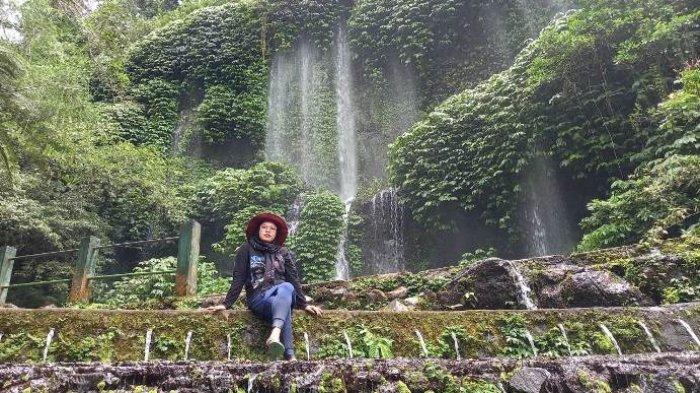 Dian, salah seorang pengunjung menikmati air terjun Benang Kelambu, di Desa Aik Berik, Lombok Tengah, Minggu, 30 Januari 2022.