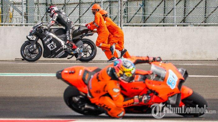 Aleix Espargaro, pembalap tim Aprilia Racing dibantu tim marshal usai terpeleset di tikungan pertama Sirkuit Mandalika, Minggu, 13 Februari 2022.