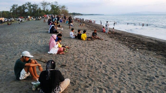 Para pengunjung duduk di tepi Pantai Loang Baloq menikmati sunset, beberapa waktu lalu. Sebagian terlihat tidak pakai masker.