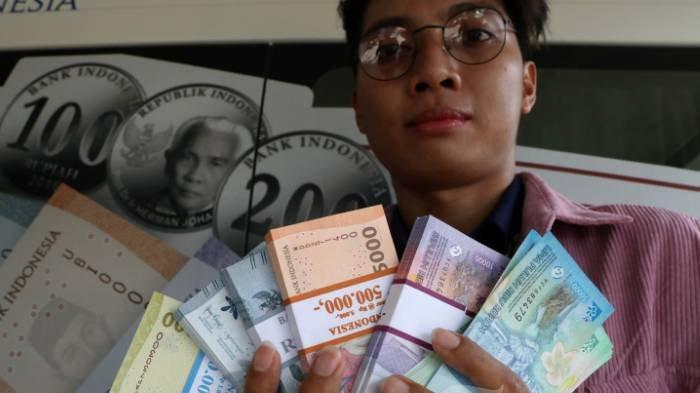 UANG BARU - Warga menunjukkan uang pecahan kecil usai melakukan penukaran uang pada mobil kas keliling Bank Indonesia (BI) di Pasar Slipi, Jakarta, Rabu (20/3/2024).