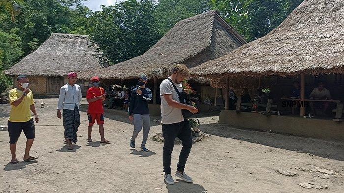 Seorang wisatawan asing berjalan mengunjungi Desa Adat Ende di Kecamatan Pujut, Kabupaten Lombok Tengah, Nusa Tenggara Barat, Rabu. Desa Adat Ende merawat tradisi kesenian tradisional Peresean, alat musik tradisional Genggong, hingga rumah yang berlantai kotoran sapi.