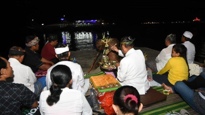 SEMBAHYANG - Keluarga salah seorang ABK KMP Tunu Pratama Jaya yang belum ditemukan, menggelar sembahyang bersama di pinggir pantai, Pelabuhan Ketapang Banyuwangi, pada hari ke tiga pencarian Sabtu (5/7/2025).