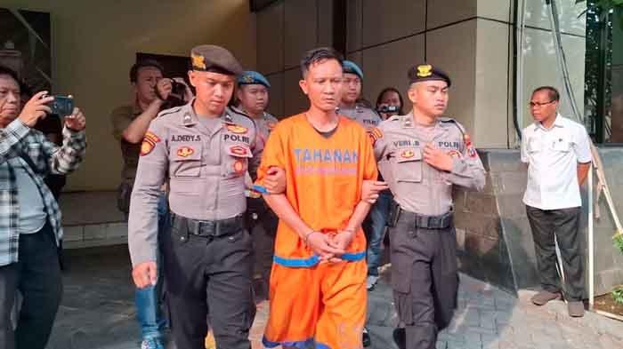 Pelaku pembunuhan terhadap istrinya sendiri saat digelandang petugas di Polresta Sidoarjo, Senin (11/11/2024).
