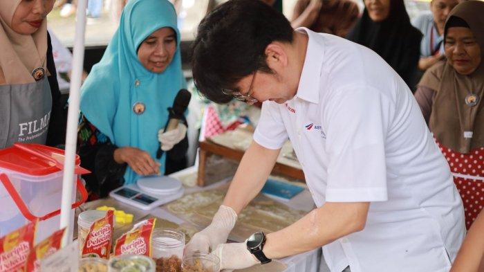 COBA ALAT - Chief Executive Astra Motor, Robien Tony mencoba alat pencetak dan pemipih di hadapan ibu-ibu pelaku UMKM Keripik Pelecing di Desa Banekaung, Kecamatan Batulayar, Kabupaten Lombok Barat, Nusa Tenggara Barat (NTB), Jumat (4/7/2025). Bantuan alat dan pemasaran ke UMKM ini merupakan bagian dari perayaan HUT ke-55 Astra Motor.