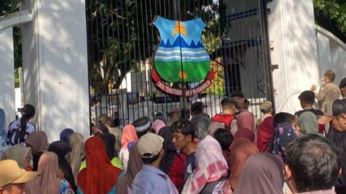 PERNIKAHAN - Warga mengantre di gerbang pendopo Garut menunggu gelaran makan gratis yang merupakan rangkaian kegiatan pernikahan Wakil Bupati Garut Putri Karlina dan Maula Akbar putra dari Gubernur Jawa Barat Dedi Mulyadi, Jumat (18/7/2025) siang. 3 orang tewas berdesakan sat mengantre makan gratis ini. 