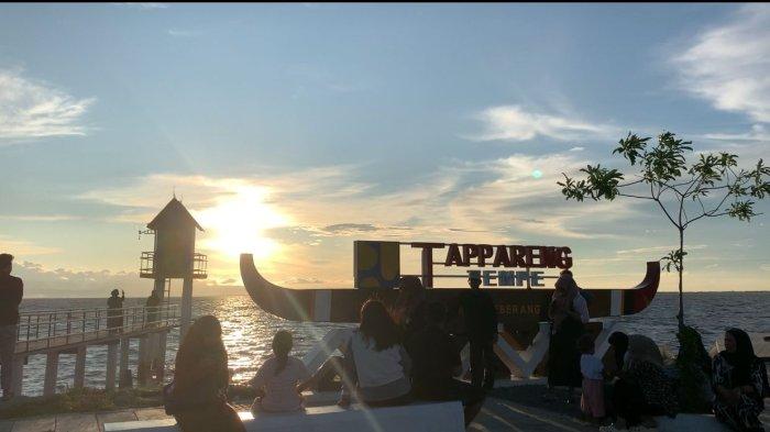 DESA WISATA - Sejumlah warga nikmati matahari tenggelam di kawasan Gelora Wisata Desa (GWD) Nepo, Jl Pelita, Desa Nepo, Kecamatan Tanasitolo, Kabupaten Wajo, Sulawesi Selatan, Selasa (15/4/2025). Mengunjungi GWD Nepo pun tak dipungut biaya, baik parkir maupun karcis masuk, semuanya gratis.