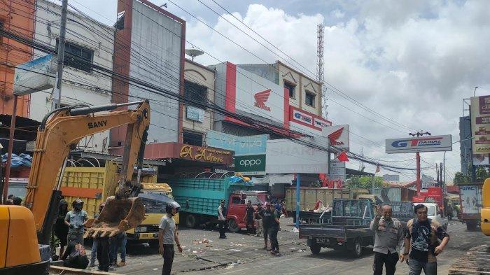 EKSEKUSI LAHAN - Suasana di Jl AP Pettarani, Kota Makassar, Kamis (13/2/2025). Puluhan truk berjejer mengangkut barang dari gedung yang akan dieksekusi.
 