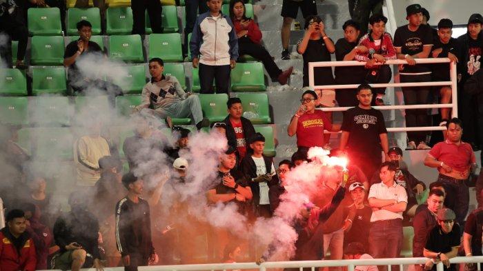 AKSI KAMPUNGAN - Seorang oknum suporter membakar flare di ujung kiri tribun terbuka Stadion BJ Habibie Parepare usai laga PSM vs CAHN FC, Rabu (2/4/2025) malam. Aksi oknum suporter tidak bertanggung jawab itu diteriaki “Kampungan… kampungan… kampungan.. “ oleh ribuan suporter lainnya.