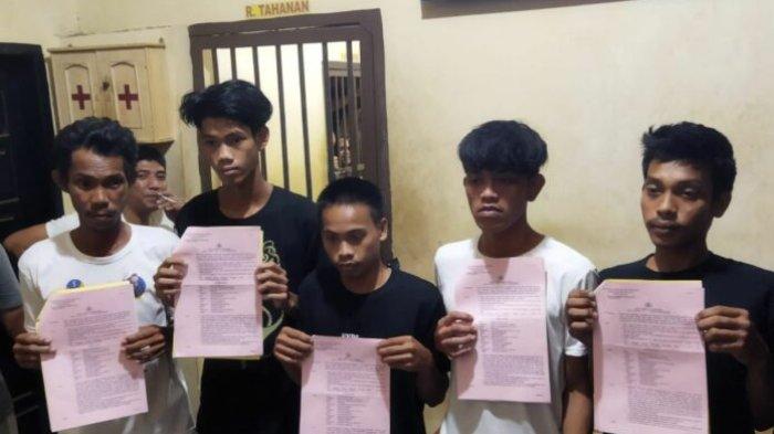 Petugas polisi membawa barang bukti uang palsu