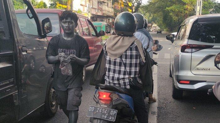 MANUSIA SILVER - Manusia Silver terlihat di persimpangan Jl Sungai Saddang dan Veteran, Jumat (9/5/2025). Mereka terlihat mengemis kepada para pengendara jalan.