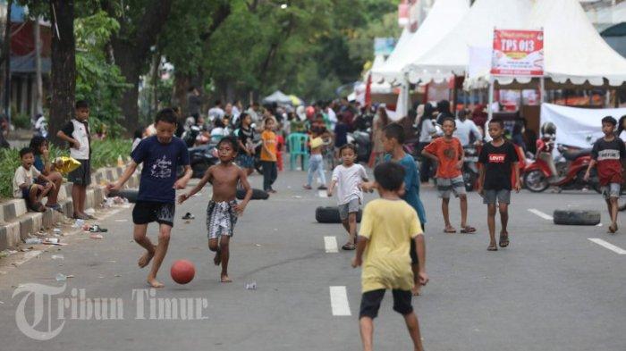 Sejumlah anak bermain bola memanfaatkan jalan yang ditutup di Jl Bandang, Makassar, Rabu (14/02/2024). Jalan yang ditutup ini digunakan untuk 13 tempat pemungutan suara (TPS) pada Pemilu 2024