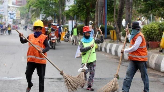 PEMKOT MAKASSAR – Tiga petugas kebersihan menyapu jalan di Anjungan Pantai Losari, Makassar, Minggu (15/11/2015) pagi.