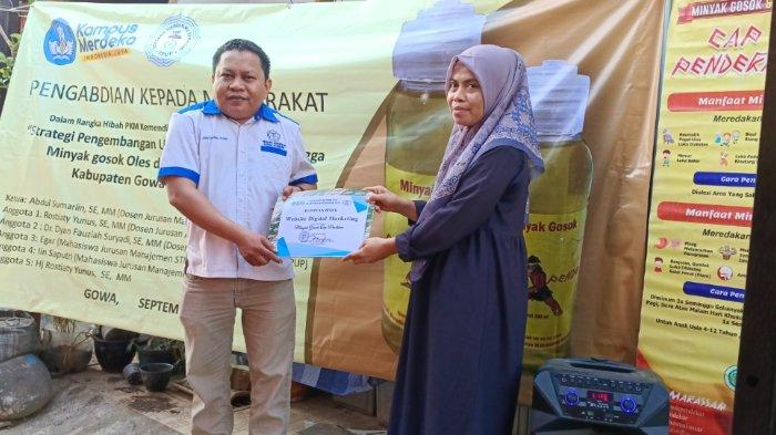 Ketua tim PkM Abdul Sumarlin memberikan sertifikat penghargaan dan bantuan peralatan produksi kepada pemilik industri rumah tangga minyak gosok oles dan minum cap pendekar berupa Website Digital Marketing, Kompor dan Blender.