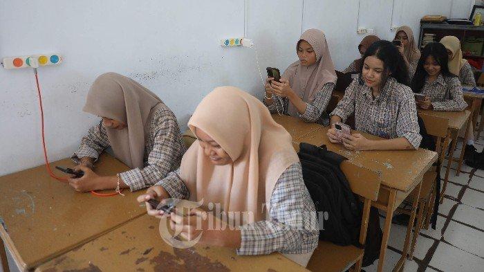 Sejumlah siswa menggunakan fasilitas listrik Tenaga Surya (PLTS) yang terpasang di SMP Negeri 6 Makassar, Rabu (28/2/2024). Pemerintah Kota Makassar melalui Dinas Pendidikan Kota Makassar menjadikan SMP Negeri 6 sebagai percontohan penggunaan PLTS dengan daya 5 kW (kilowatt) sebagai upaya pembangunan berkelanjutan yang ramah lingkungan dan mengurangi ketergantungan terhadap energi fosil.
