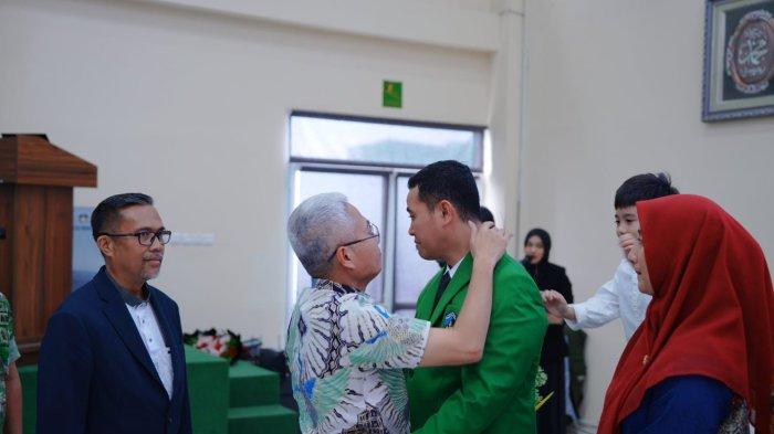 Dr M Yusran Lalogau (32), berurai air mata saat dipeluk pamannya, Adnan Muis RMS (52) usai promosi doktor perikanan di UMI Makassar, Jumat (26/7/2024) pagi