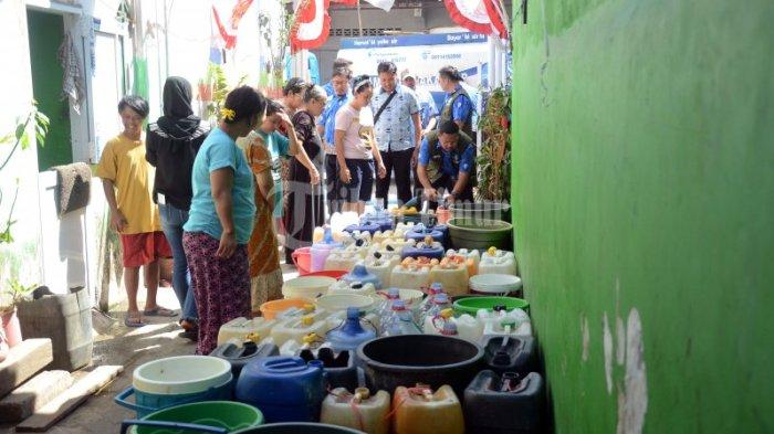 Petugas Perusahaan Air Minum Daerah (PDAM) menyalurkan air bersih gratis untuk warga yang berada di Kecamatan Tallo, Makassar, Kamis (31/8/2023). Penyaluran air bersih ini dilakukan secara berkala untuk menutupi defisit pasokan air bersih yang terjadi akibat dampak kekeringan.