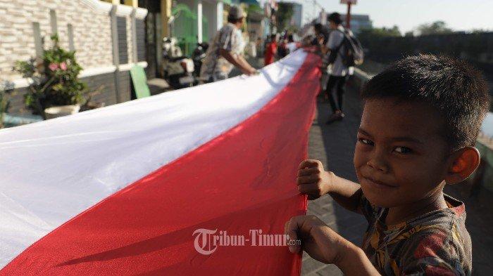Sejumlah warga membentangkan bendera Merah Putih di Kelurahan Lette, Kecamatan Mariso, Makassar, Sabtu (17/8/2024). Pembentangan bendera sepanjang 1.000 meter tersebut untuk memeriahkan peringatan HUT ke-79 Kemerdekaan RI sekaligus menumbuhkan rasa nasionalisme warga khususnya para pemuda dan anak-anak di daerah itu.