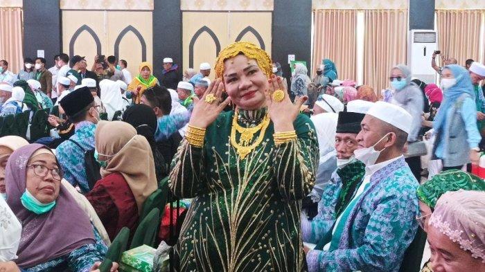 Jemaah haji asal Makassar Suarnati Daeng Kanang (46) balut dirinya dengan emas 180 gram saat kembali ke tanah air. Ia memamerkan emas yang dikenakan saat tiba di Asrama Haji Sudiang, Makassar, Rabu (5/7/2023)