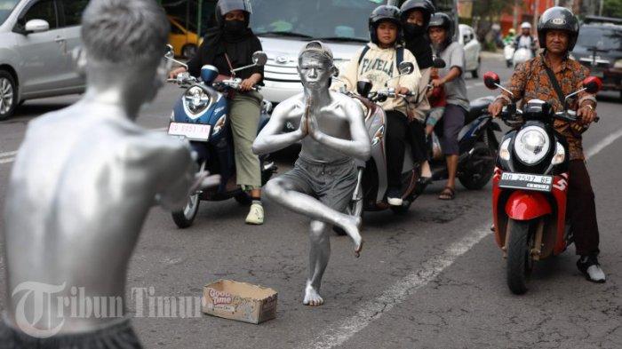 Sejumlah manusia Silver beraksi di traffic light perempatan Jl Gunung bawakaraeng dan Jl Veteran, Makassar, Senin (6/2/2023).