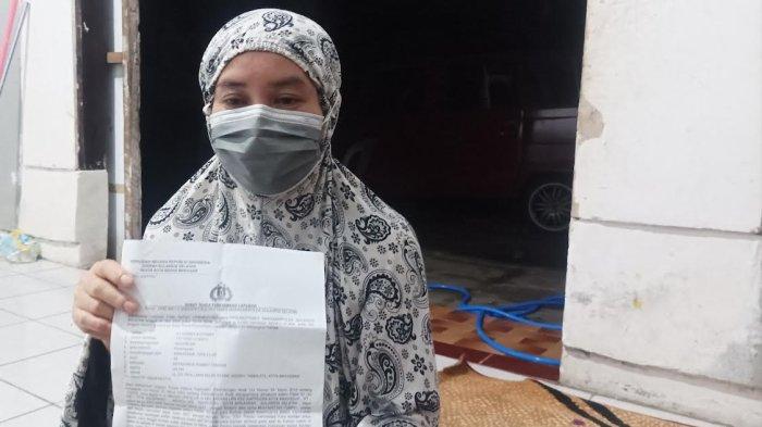 Orang tua korban pelecehan memperlihatkan laporan polisi di rumahnya di Kecamatan Rappocini, Makassar.