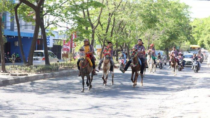 Sejumlah penunggang kuda melintasi Jalan Aeropala, Makassar, Jumat (28/7/2023). Pasukan berkuda ini menjadi bagian dari proses Appa’bunting yang berarti upacara pernikahan. Tugas mereka menjadi pembuka jalan rombongan pengantin Pria yang hendak menuju ke rumah pengantin wanita.
