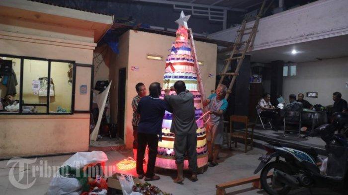 Sejumlah pengurus gereja memasang ornamen pohon natal didepan Gereja Jemaat GPIB Bukit Zaitun, Jl Cendrawasih, Makassar, Sabtu (16/12/2023) malam. Pohon natal dari bahan dasar botol plastik bekas tersebut  dalam rangka menyambut perayaan Hari Natal 2023.