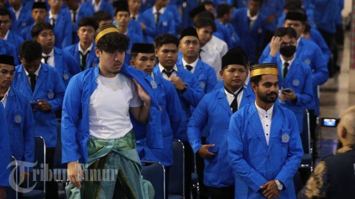 Dua mahasiswa dari negara asing memakai jas Almamater Unismuh usai resmi dikukuhkan dalam Rapat senat yang berlangsung di Balai Sidang Muktamar Muhammadiyah, Kampus Unismuh Makassar, Jl Sultan Alauddin, Selasa (19/09/2023). Sebanyak 3.767 mahasiswa hadiri Prosesi pengukuhan Maba yang ditandai dengan pembacaan ikrar yang dipimpin Rektor Unismuh.