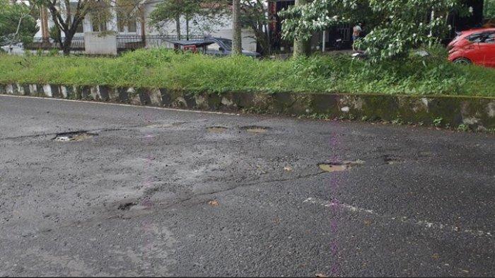 LUBANG - Jalan rusak dan berlubang terlihat di Jalan Paloko Kinalang, Kelurahan Kotobangon, Kota Kotamobagu, Sulawesi Utara. Pantauan TribunManado.co.id pada Selasa (15/4/2025).